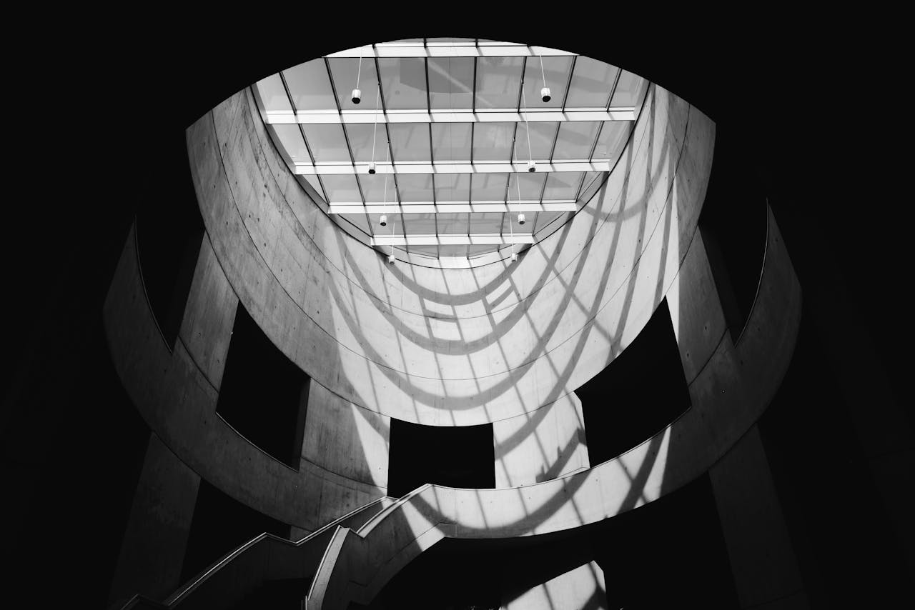 Dramatic black and white photo of a modern architectural staircase with skylight.